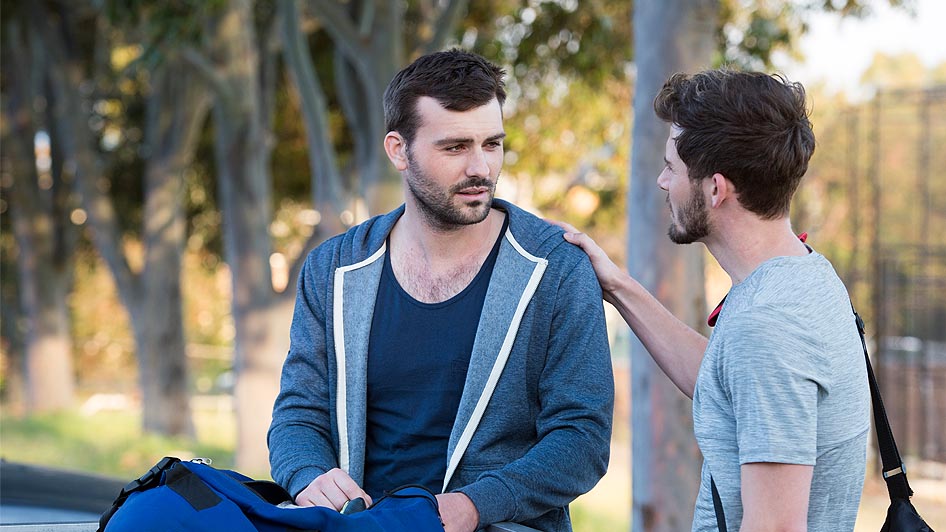 Two men chatting to each other in a park