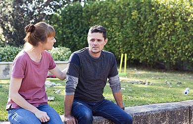 Mother offering support to her son in garden