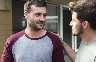 Man resting helping hand on friends shoulder