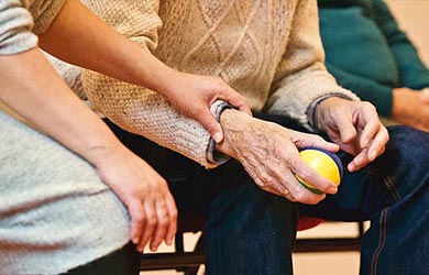 Carer holding pensioners hand