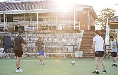 Guys playing soccer outside clubhouse